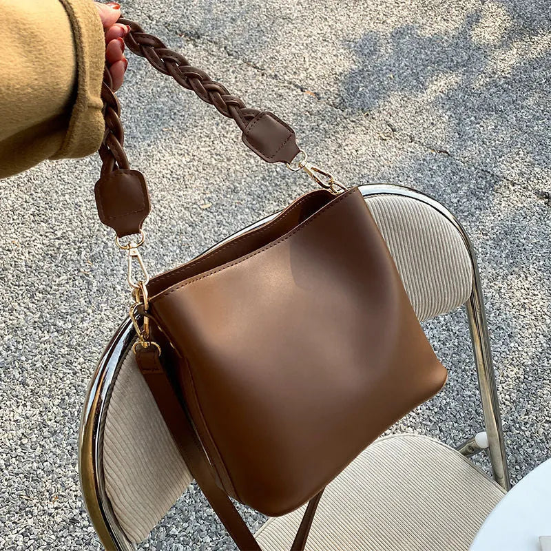 Retro style brown PU leather underarm bucket bag with woven design detail.