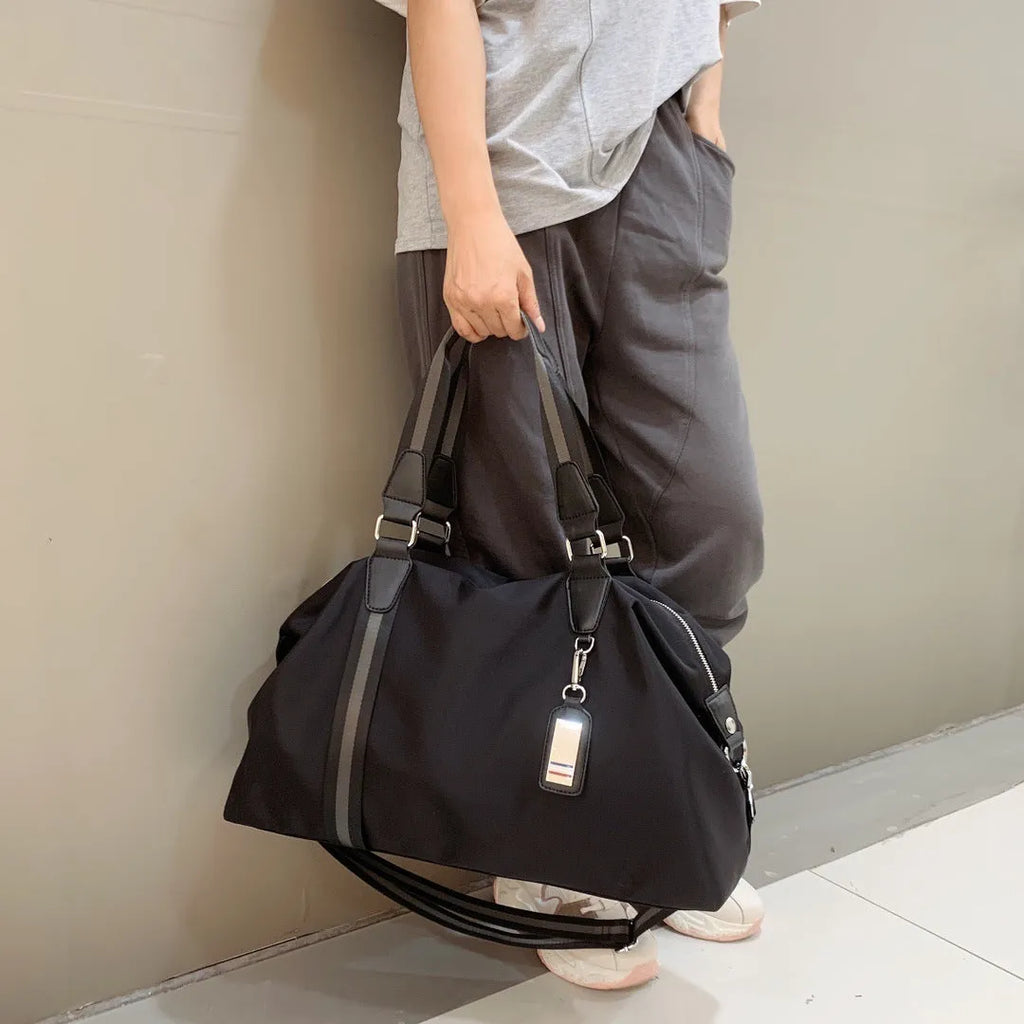 Men's black gold Oxford cloth travel bag with zipper opening and three shoulder straps shown on a neutral background
