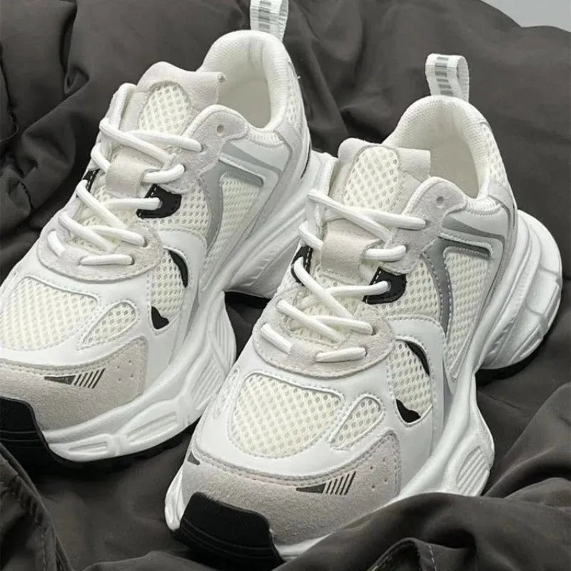 Beige mesh platform sports shoe with a wedge heel and front lace-up design on a white background.
