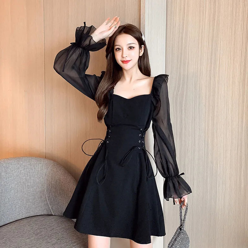 White chiffon patchwork dress with long sleeves and a waist-slimming silhouette on a hanger.
