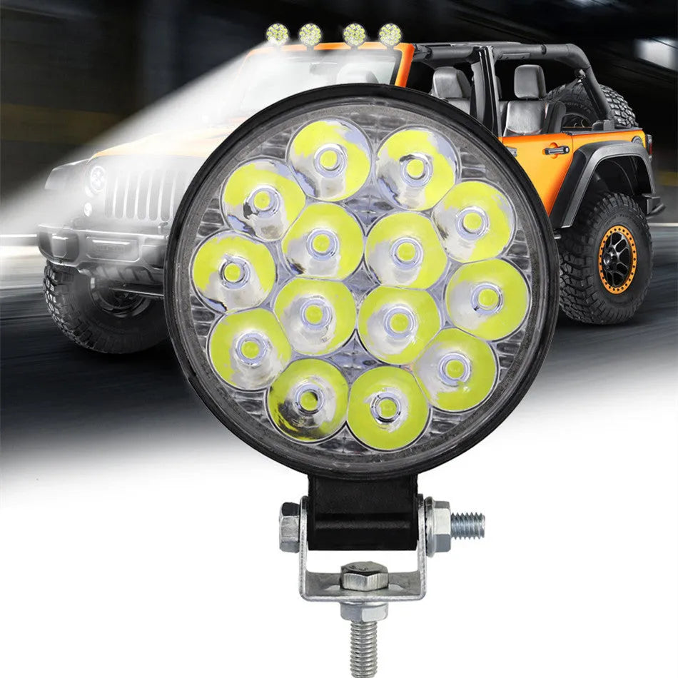 Round mini aluminium LED work light showing white light beam, suitable for vehicle mounting.