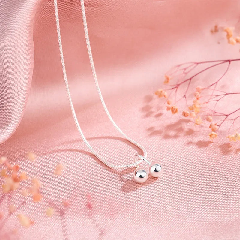 Silver cherry necklace for women with adjustable snake bone chain and fruit-shaped pendant.