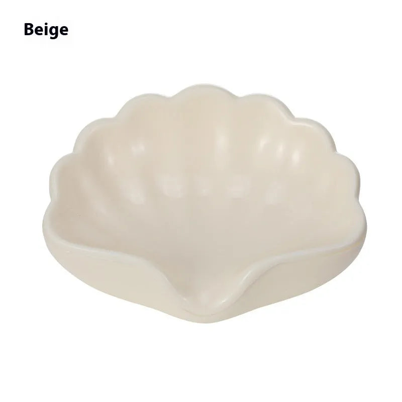 White and pink plastic shell-shaped soap dish for bathroom counter.