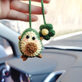 Handmade crocheted avocado-shaped car pendant in wool, shown in three colour variations.