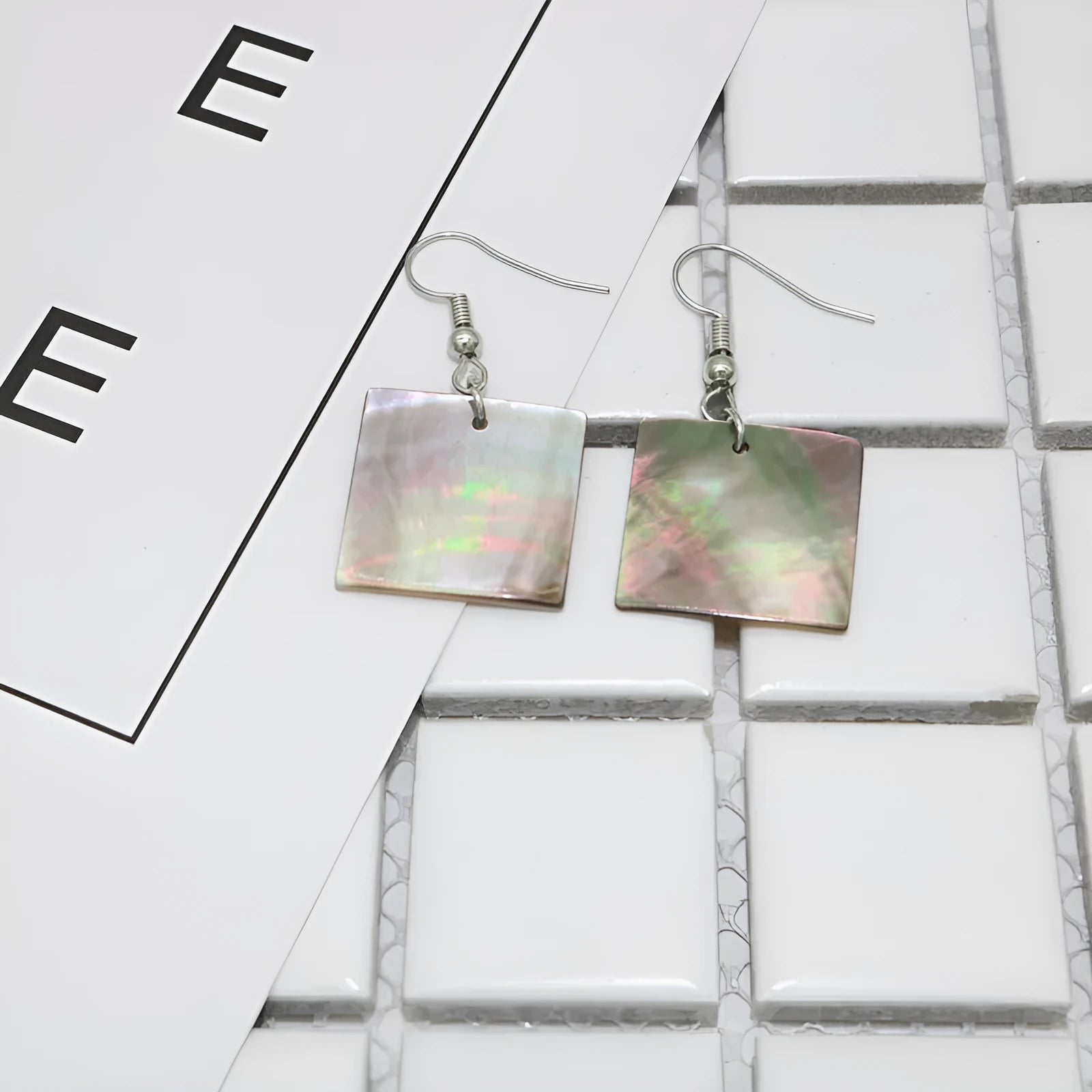 Geometric shell earrings in square panther or rectangular shell styles with natural material texture