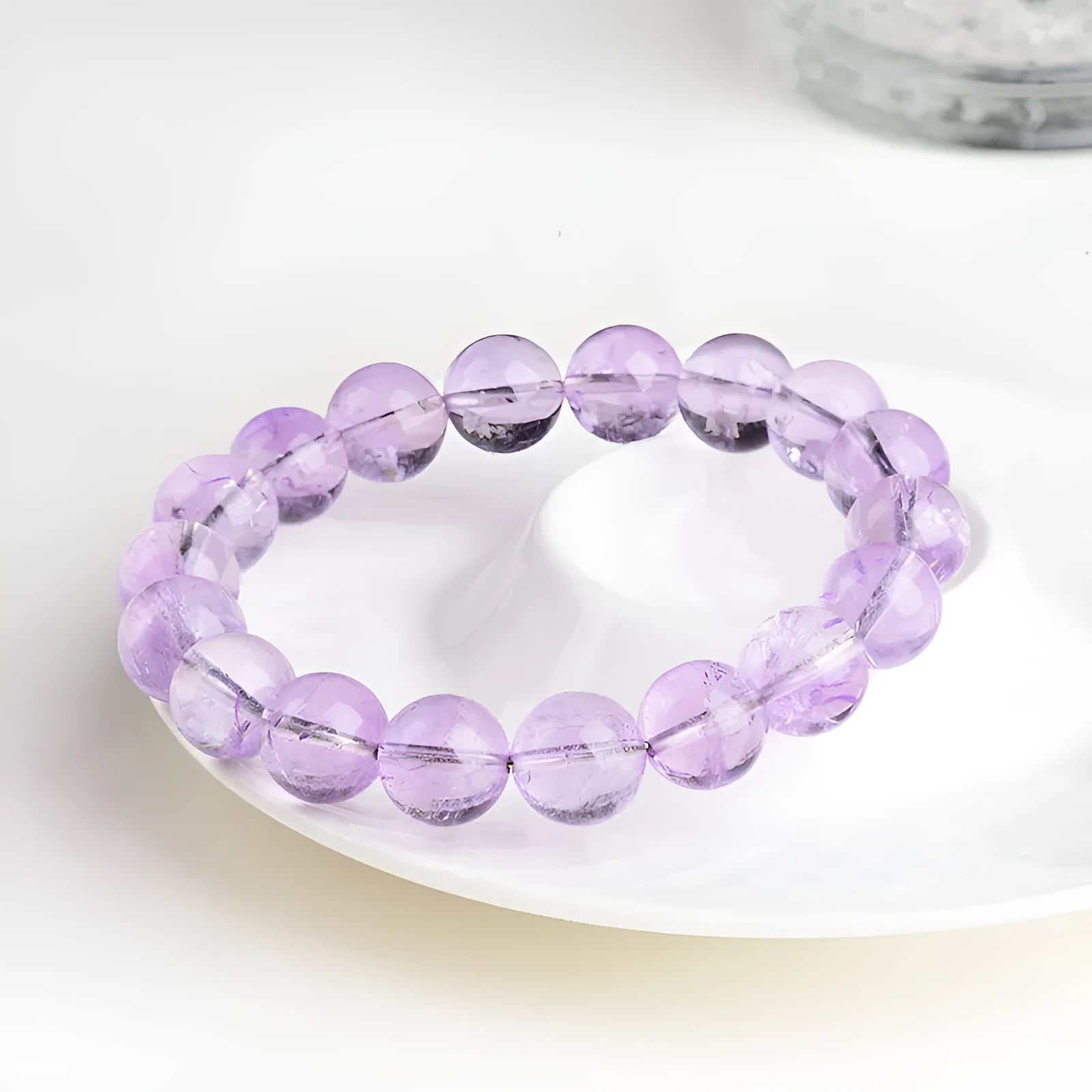 Lavender round amethyst bead bracelet with geometric water ripple design on a wrist.