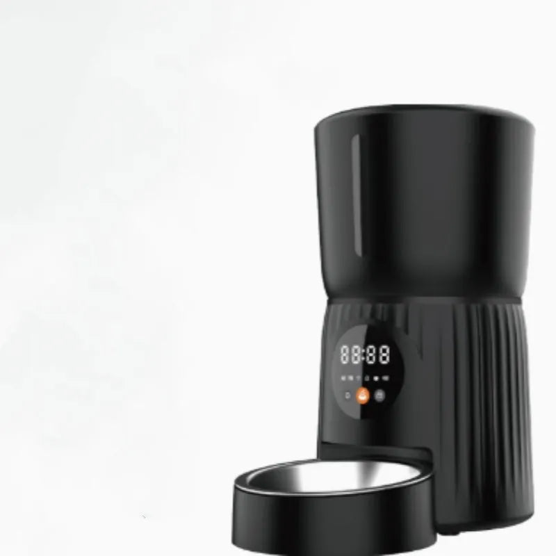Black and white smart automatic pet feeder with USB cable and mobile app display showing feeding schedule.