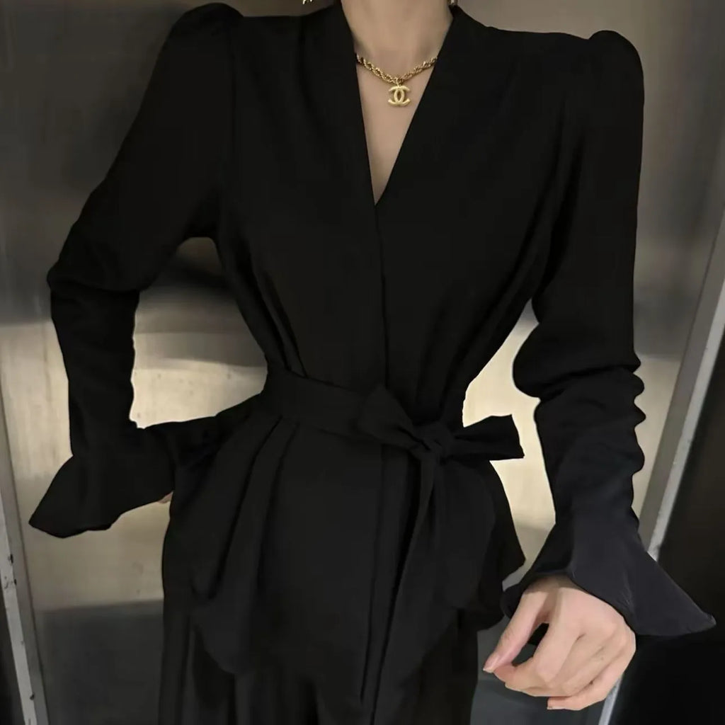 Women's black French-style shirt with irregular collar, long bell sleeves, and tied front detail.