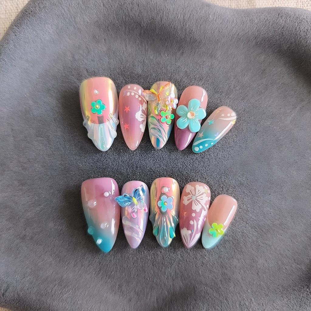 Handmade floral and butterfly nail art sculptures for manicure decoration in almond shape.