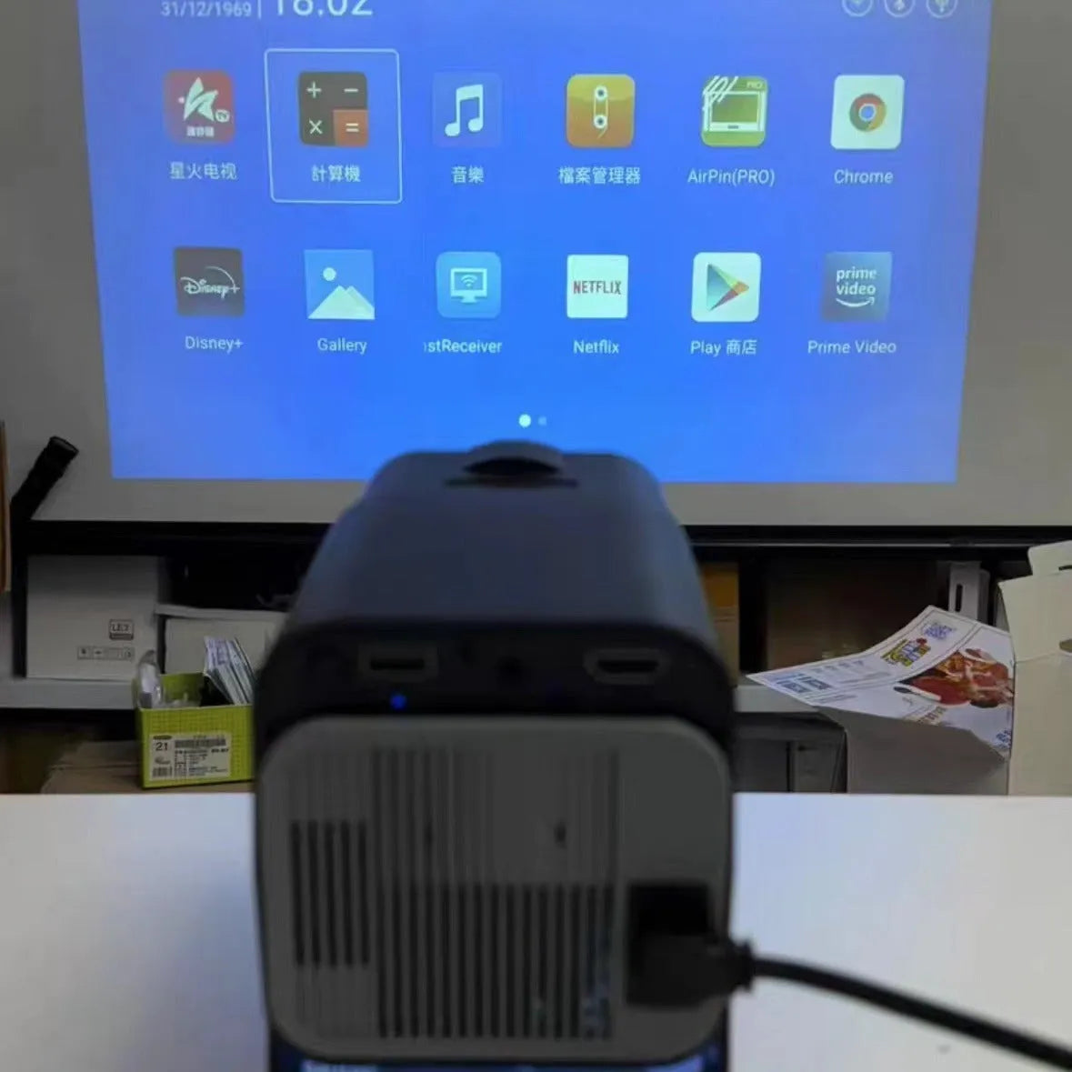 Home projector unit with carrying handle showing 720p HD and wireless projection features