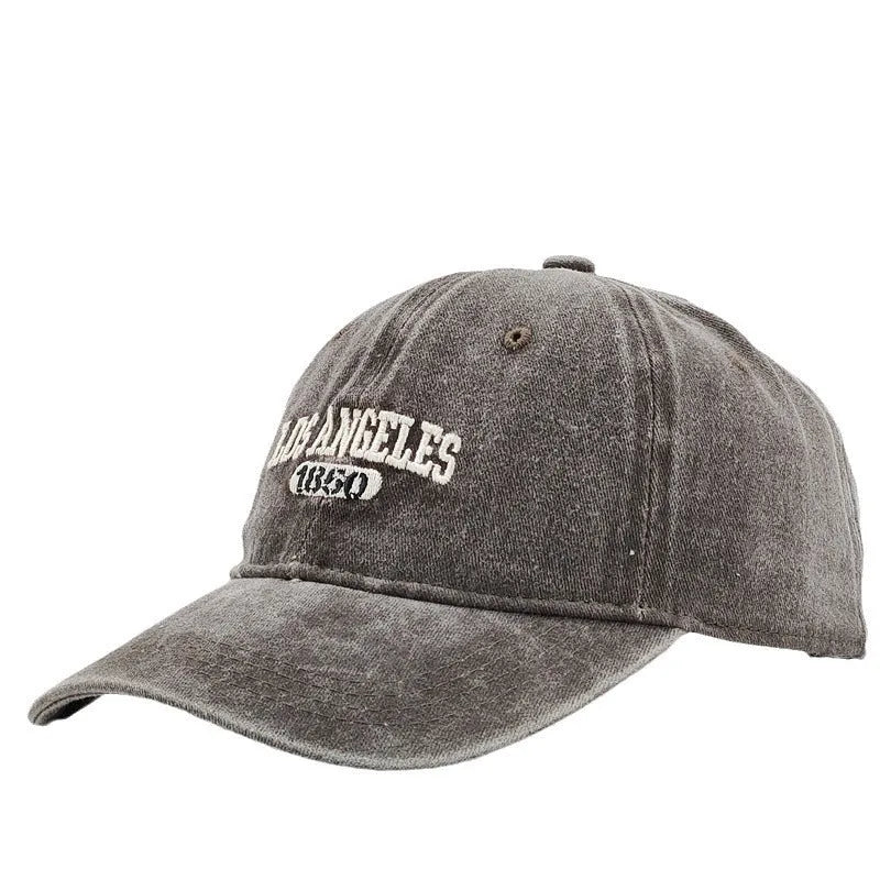Retro-style adjustable acrylic peaked cap with embroidered letters, shown in a distressed beige colour.