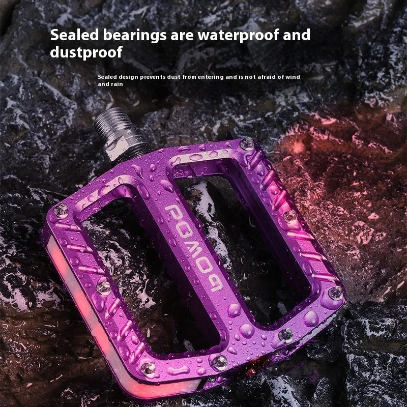 Pair of aluminium alloy bicycle pedals with integrated LED lights in multiple colour options.