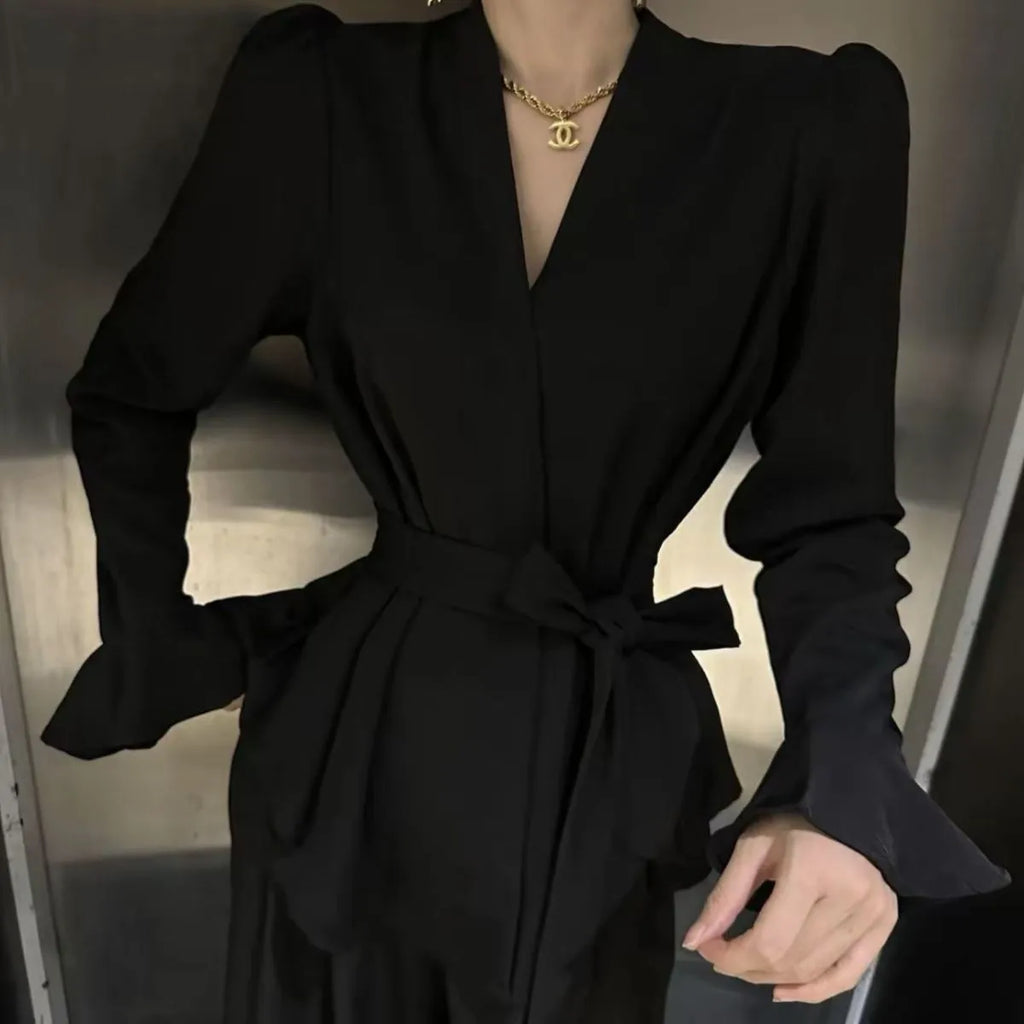 Women's black French-style shirt with irregular collar, long bell sleeves, and tied front detail.