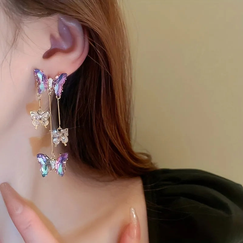 Silver needle alloy drop earrings featuring a blue purple butterfly design with crystal accents and tassel details.
