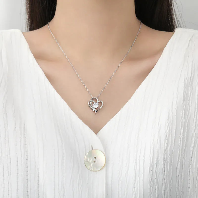 Close-up of a women's heart-shaped pendant necklace in 925 silver with a diamond-treated finish