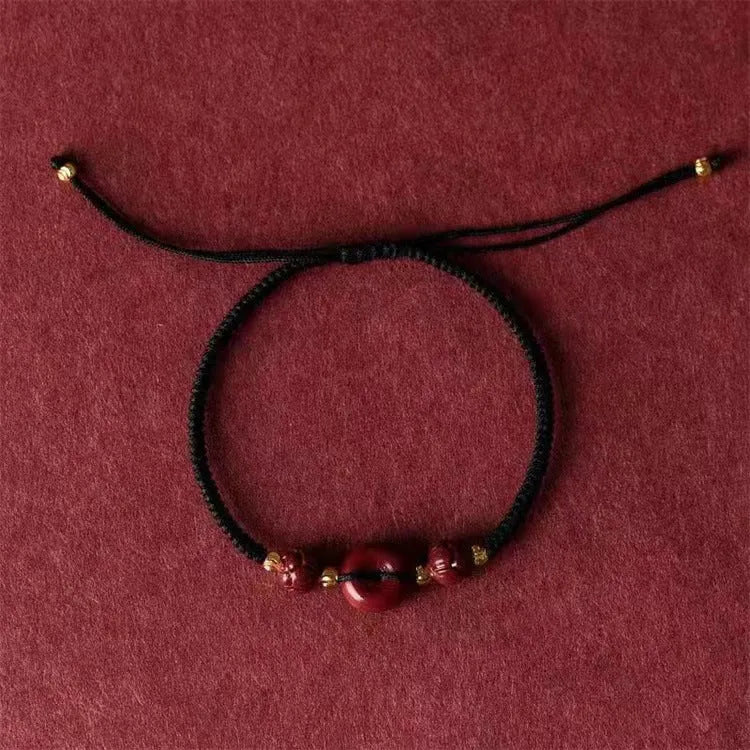 Heart-shaped cinnabar pendant on adjustable safety buckle bracelet with red cord