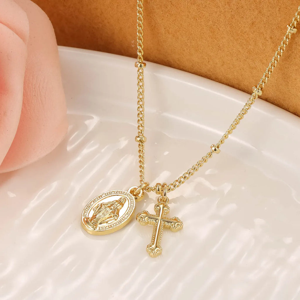Geometric Virgin Mary and cross pendant necklace in 18K gold colour on a copper chain.