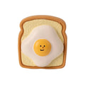 Yellow or green cartoon bread-shaped latex chew toy for dogs with a squeaker inside.