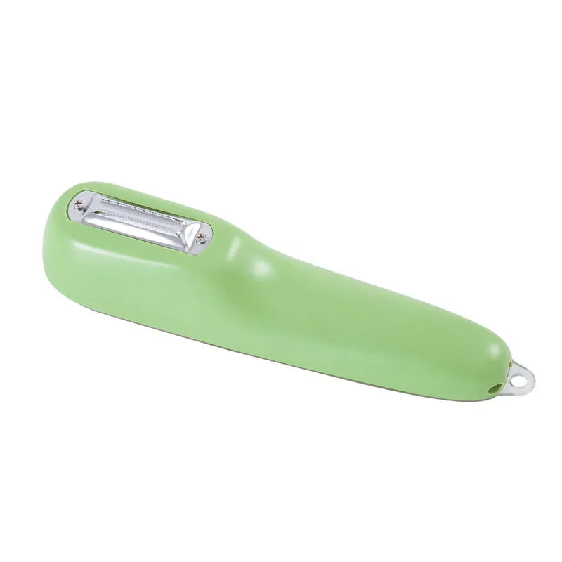 Dark green vegetable peeler with stainless steel blade inside its clear plastic storage tube on a kitchen counter.