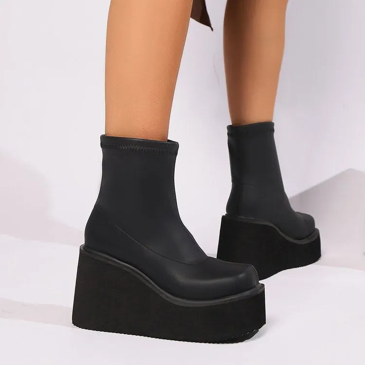 Plus size black wedge heel boots with a waterproof platform and round toe on a white background.