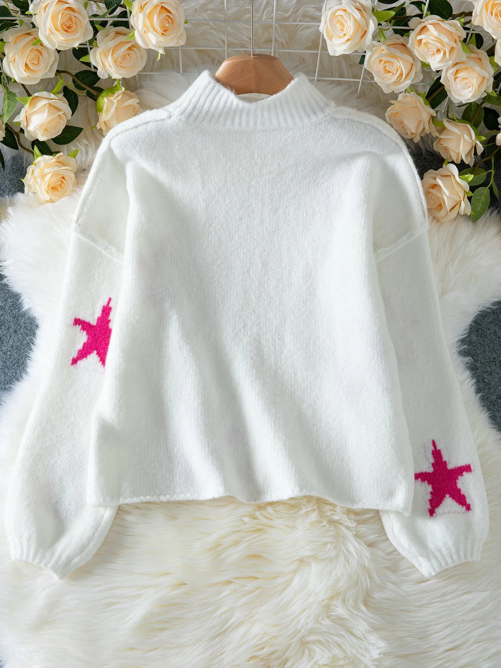 White women's loose turtleneck sweater with a large black five-pointed star pattern on the front.