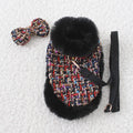 Small dog wearing fabric cape with matching beret, attached to chest strap and lead