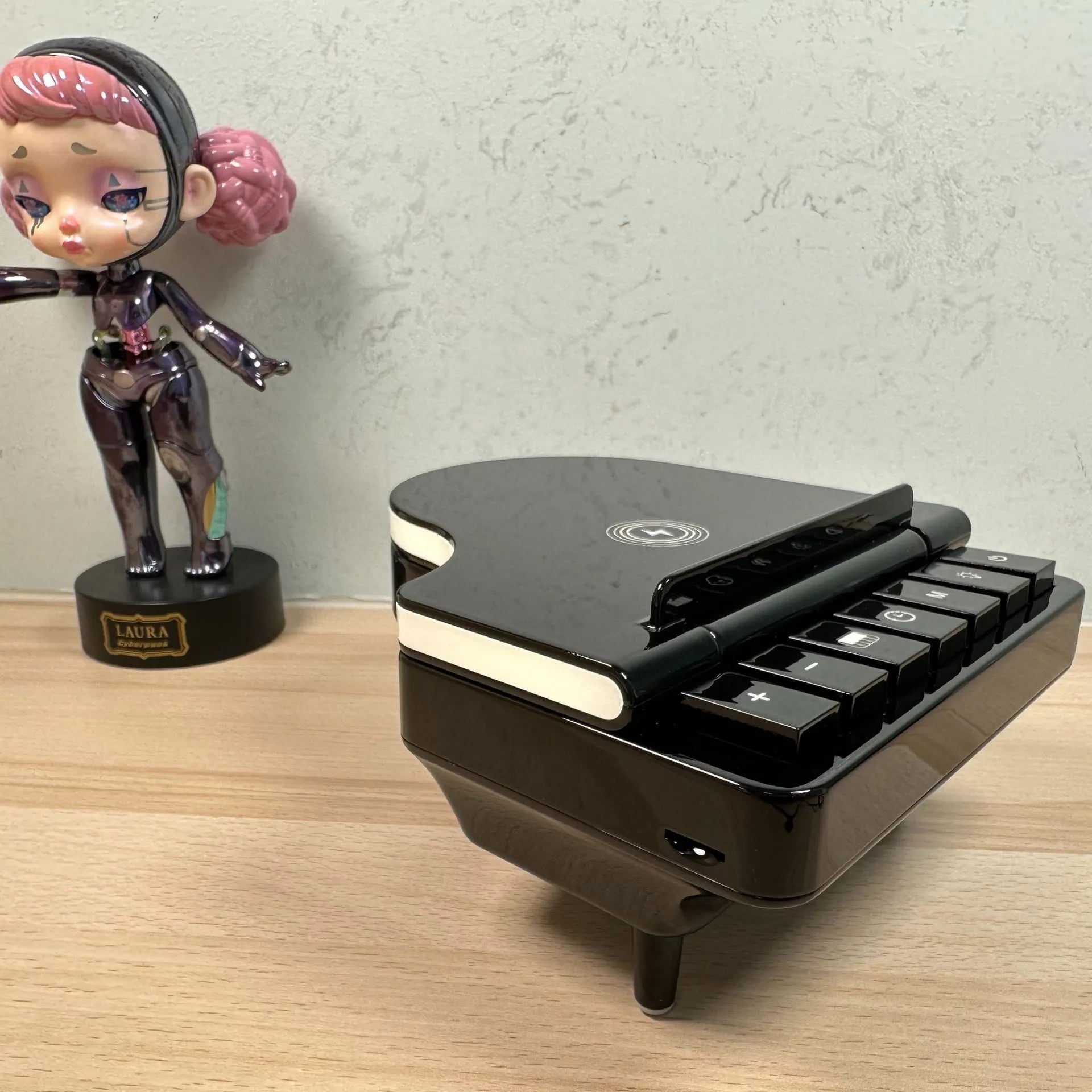 Black 3-in-1 Bluetooth speaker with wireless charger and phone holder on a desk