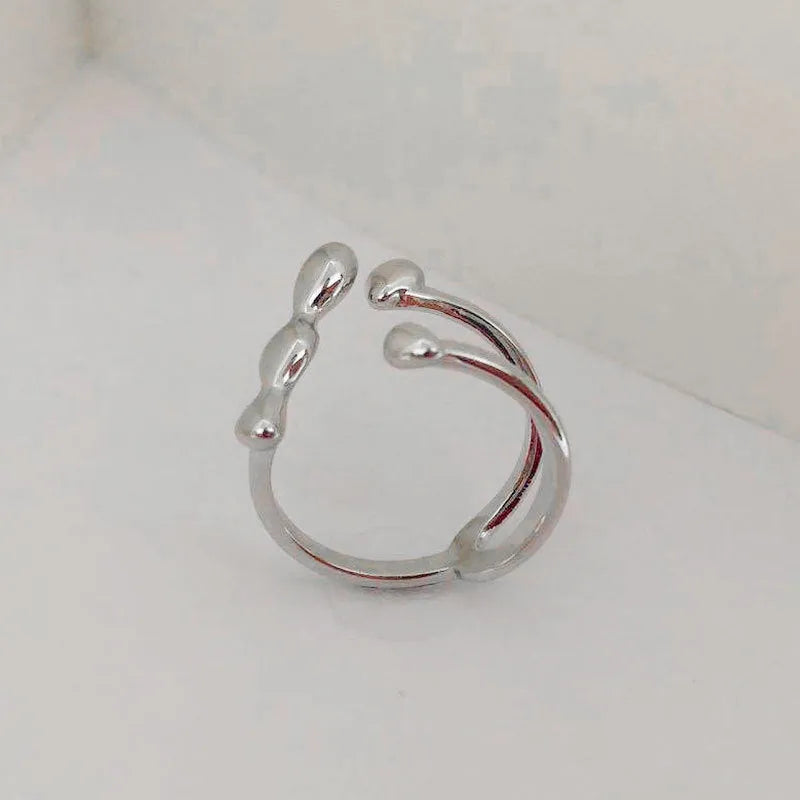Gold and silver brass opening ring with sphere circle design on a woman's hand.