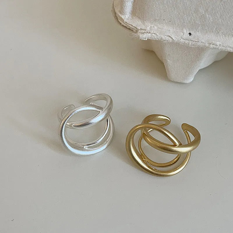 Geometric open ring for women with 3D interlaced matte metal design in gold and silver colour options.