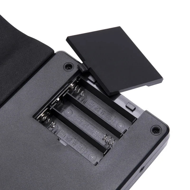 Folding electronic keyboard with 49 silicone keys, shown in gloss black, folded to compact size with speaker visible on control panel