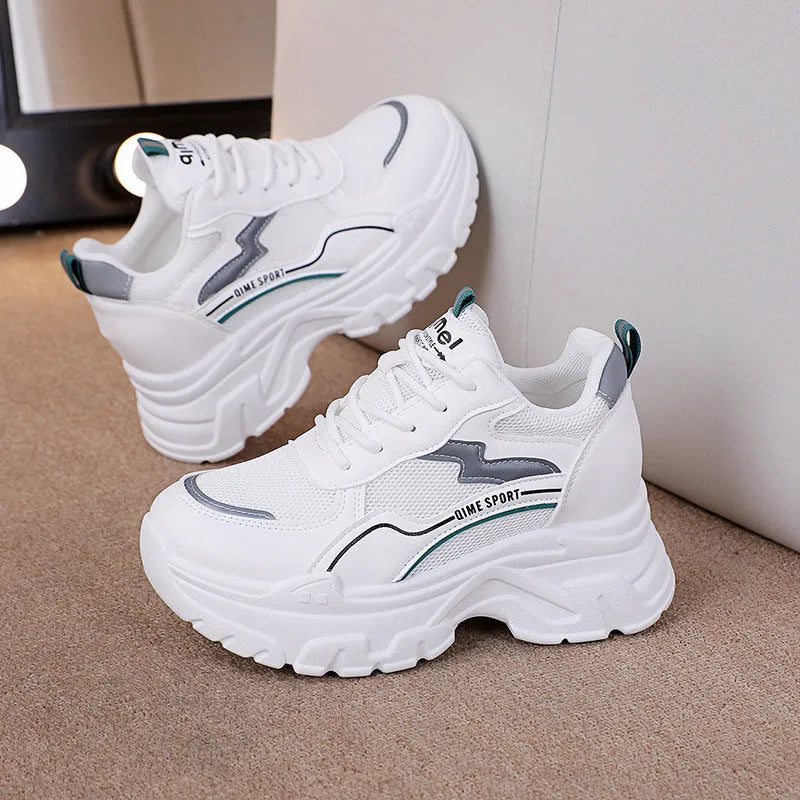 White women's low-top sports trainers with a front lace-up and cross-strap detail.