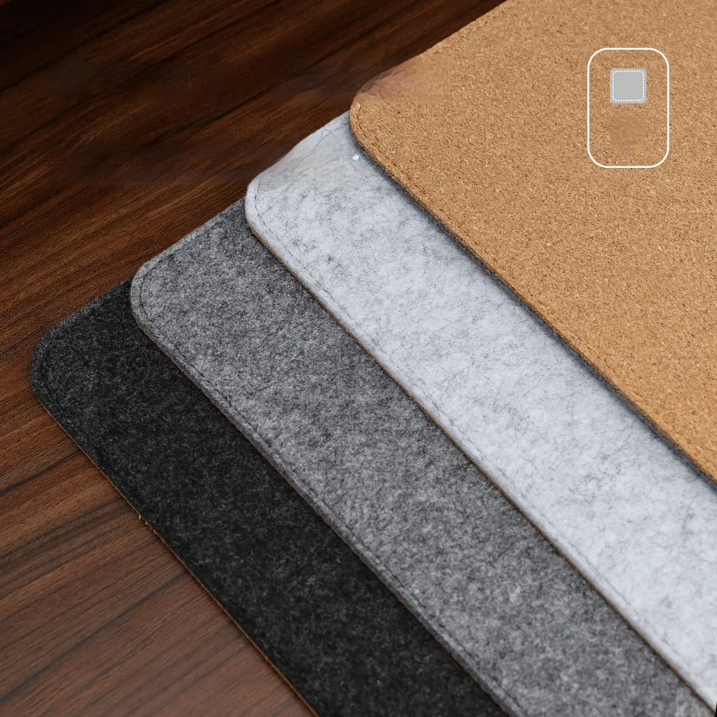 A winter warm felt cork office desk mat in a grey colour pattern, shown on a wooden desk with a mouse.