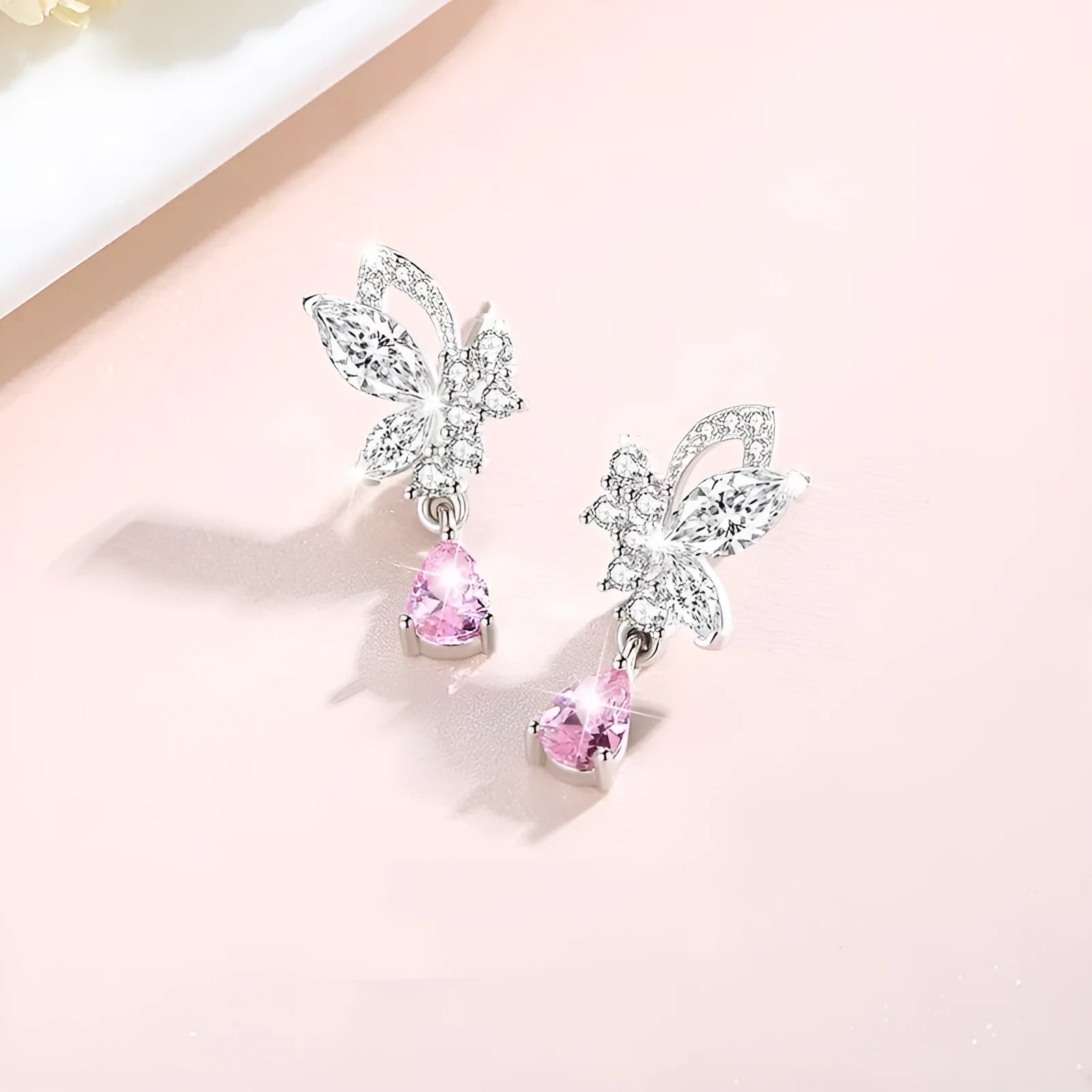 A pair of silver stud earrings with a faceted crystal butterfly design on a post backing.