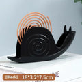 Black plastic mosquito incense holder with creative animal style on a flat surface