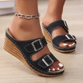 Women's creamy-white beach slippers with a black outer wedge belt buckle closure on a rubber sole.