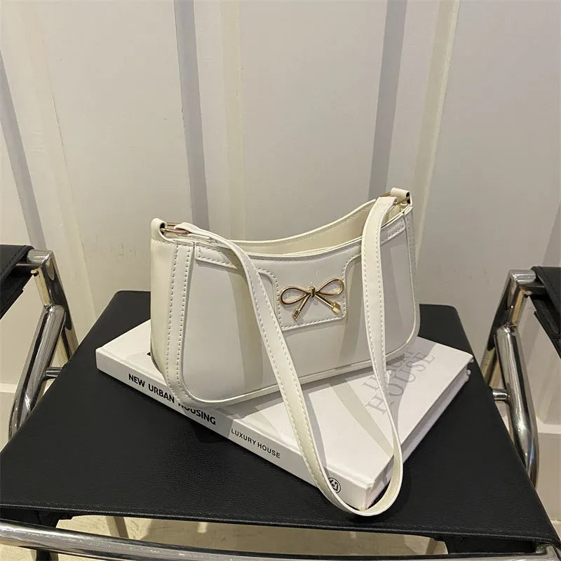 PU leather shoulder bag with bow decoration in a horizontal square shape, shown in one of six available colours.