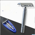 Double edged safety razor with metal handle and head next to its blade and storage box.