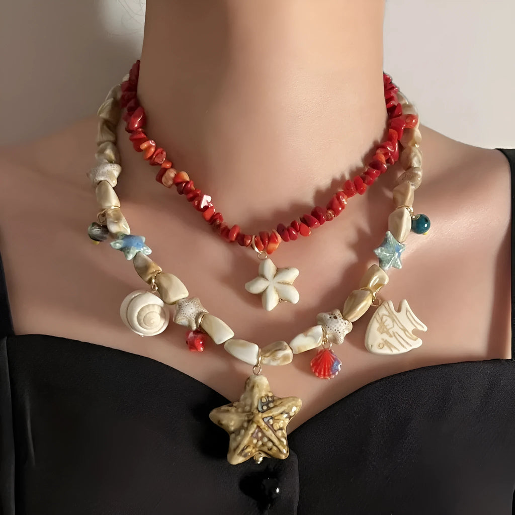 Gold marine life clavicle chain with conch shell and starfish pendant on display