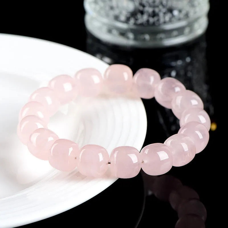 Pink barrel crystal bead bracelet with geometric design on wrist.