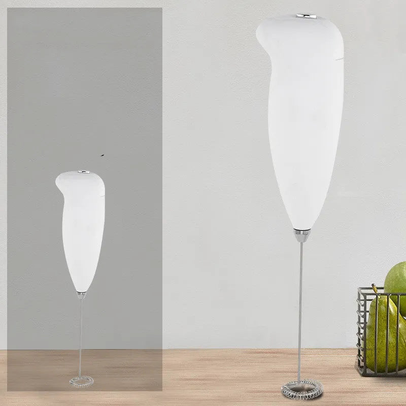 Home mini electric plastic milk frother in black on white background, 5x3x21cm