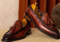 Men's black genuine leather slip-on loafers with a fringed design and rubber sole.
