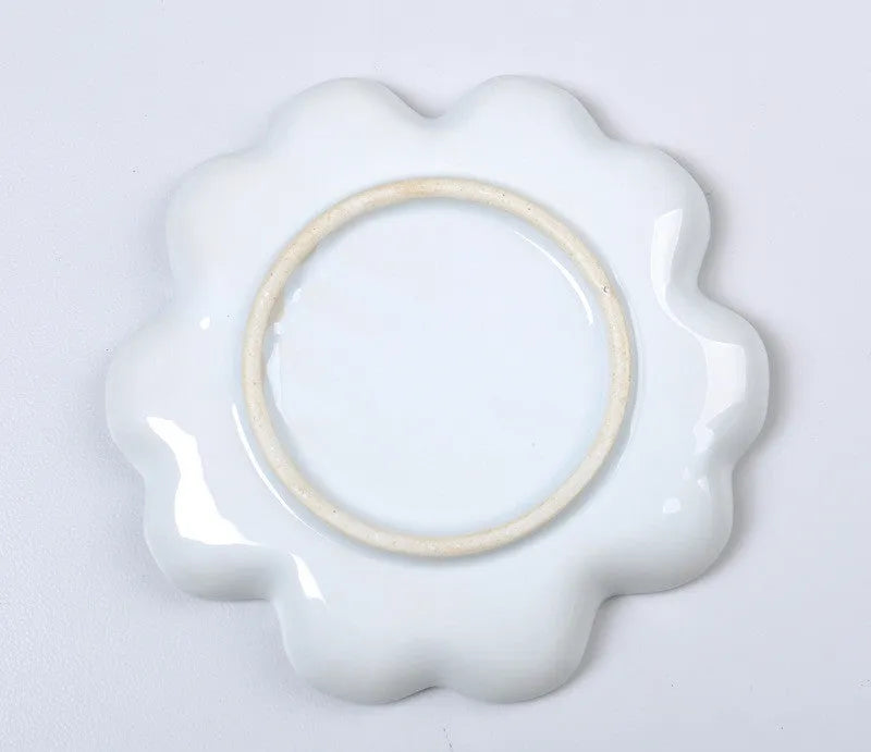 White handmade ceramic plum blossom shaped artist palette for painting.