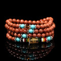 Golden star stone nugget bracelet with mantra beads and a retro fu charm on a wrist.