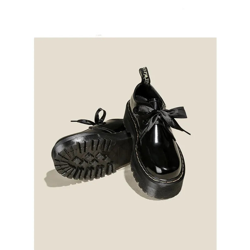 Black women's thick soled lace-up shoes with ribbon and cross strap detail on a superfine fibre upper.