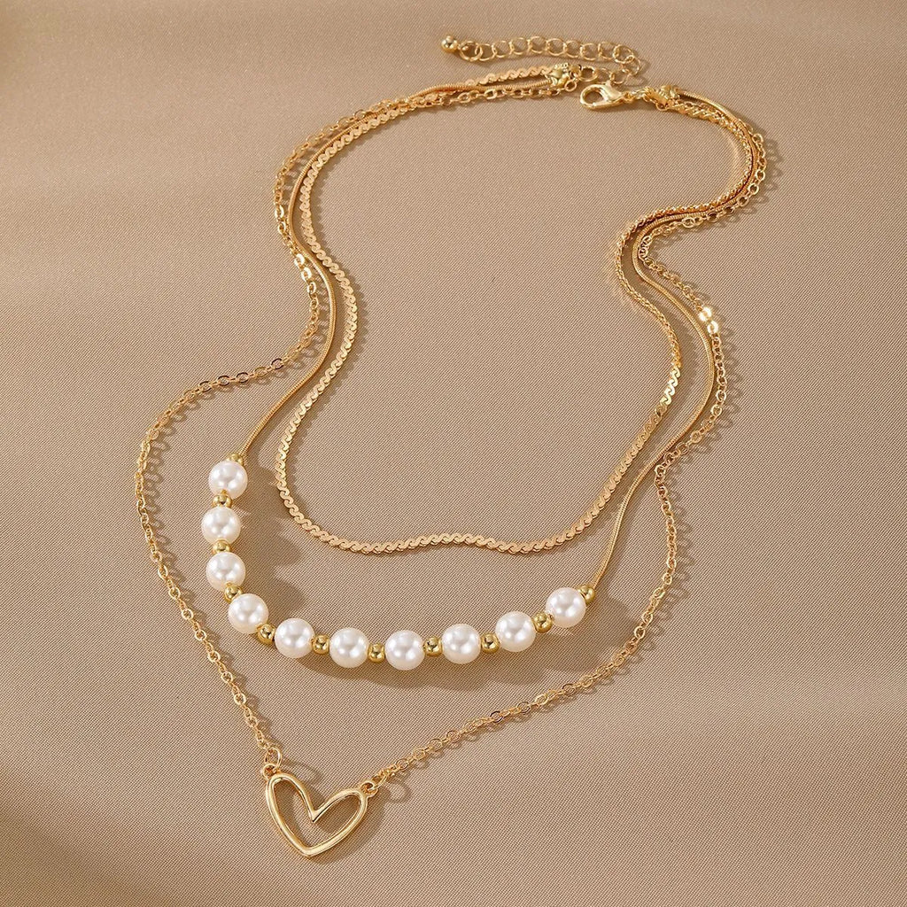 Gold electroplated vintage necklace with heart-shaped pendant on an adjustable pearl-style chain.