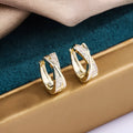 Geometric shape copper earrings with zircon accents in 14K yellow gold tone.