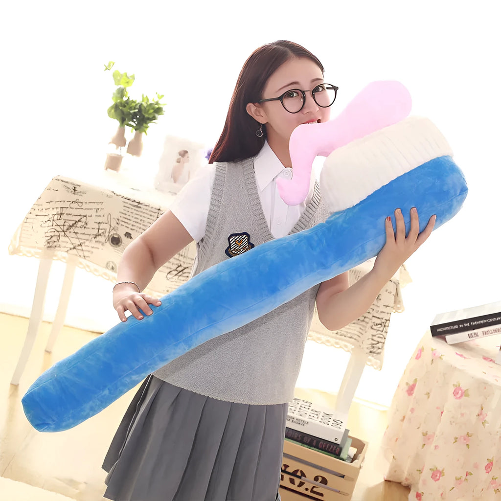 Cartoon toothbrush plush pillow 90cm in blue, green, pink, and yellow on a bed