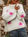 White women's loose turtleneck sweater with a large black five-pointed star pattern on the front.