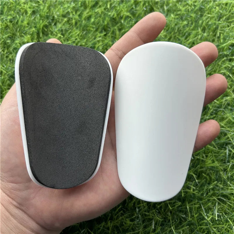 Extra small mini football shin guards in black and white measuring 8cm by 5cm