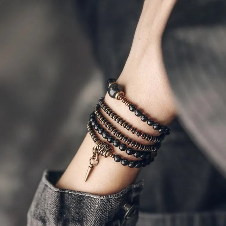 Black multi-layered beaded bracelet with geometric styling on wrist